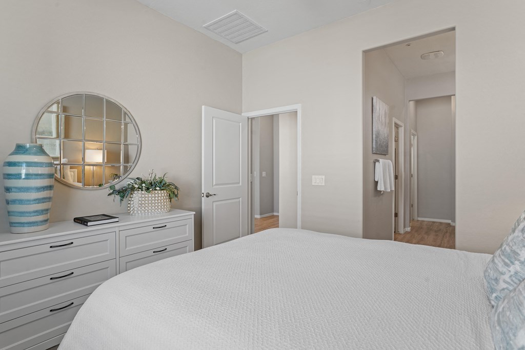 a bedroom with a white bed and a mirror at Sienna at South Mountain Apartments, Laveen