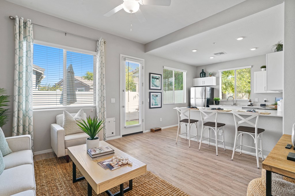 an open living room and kitchen with a dining table and chairs at Sienna at South Mountain Apartments, Laveen, Arizona