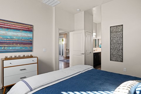 a bedroom with a bed and a bathroom with a sink at Olive Queen Creek Apartments, Queen Creek, AZ
