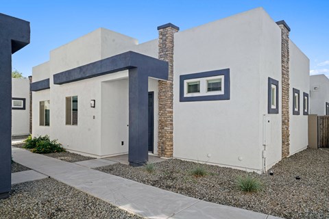 the front of a white house with blue trim and a sidewalk at Olive Queen Creek Apartments, Queen Creek, AZ, 85142