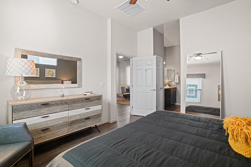 a bedroom with a bed and a dresser with a mirror