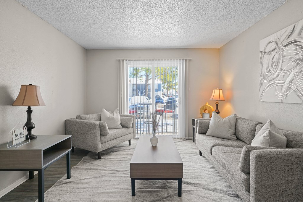 a living room with couches and a coffee table and a balcony