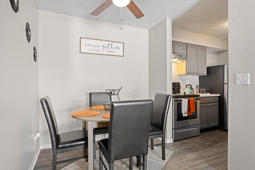 a dining area with a table and chairs and a kitchen