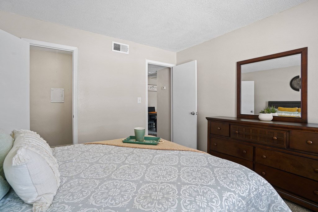 a bedroom with a bed and a dresser and a mirror
