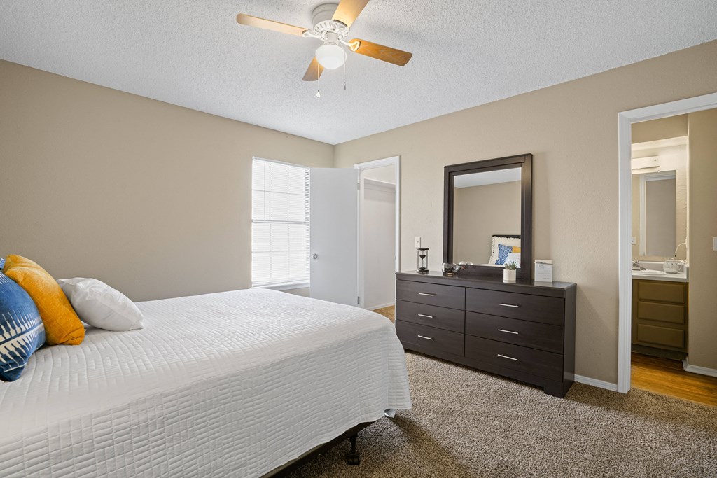 bedroom with orange and blue pillows on bed