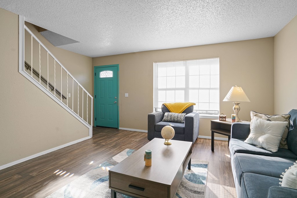 living room with stairs, couch, table and window