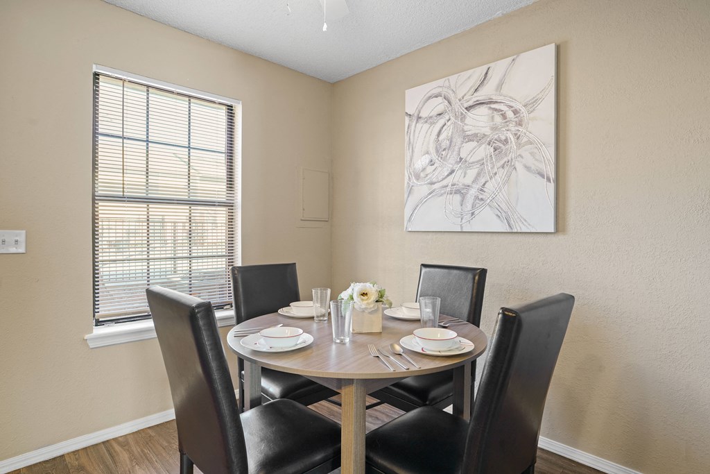 dining room area with brown table and brown chairs and large window