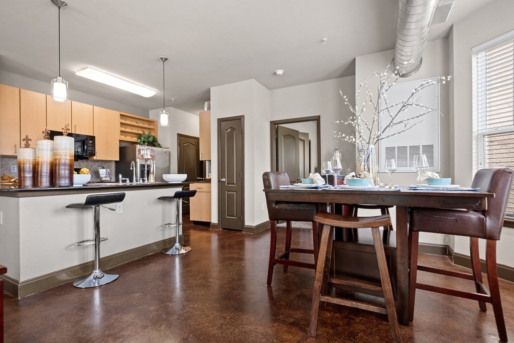 an open kitchen and dining room with a table and chairs at The Millennium Towne Center Apartments, Baton Rouge, LA