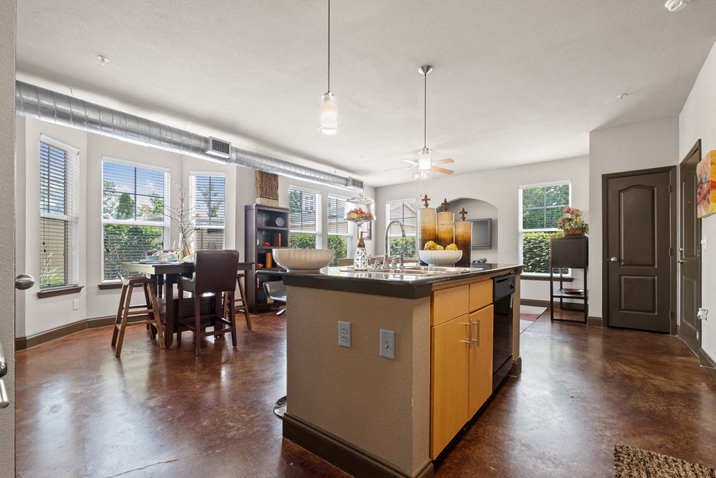 a kitchen with a large island in the middle of a living room at The Millennium Towne Center Apartments, Baton Rouge, 70806