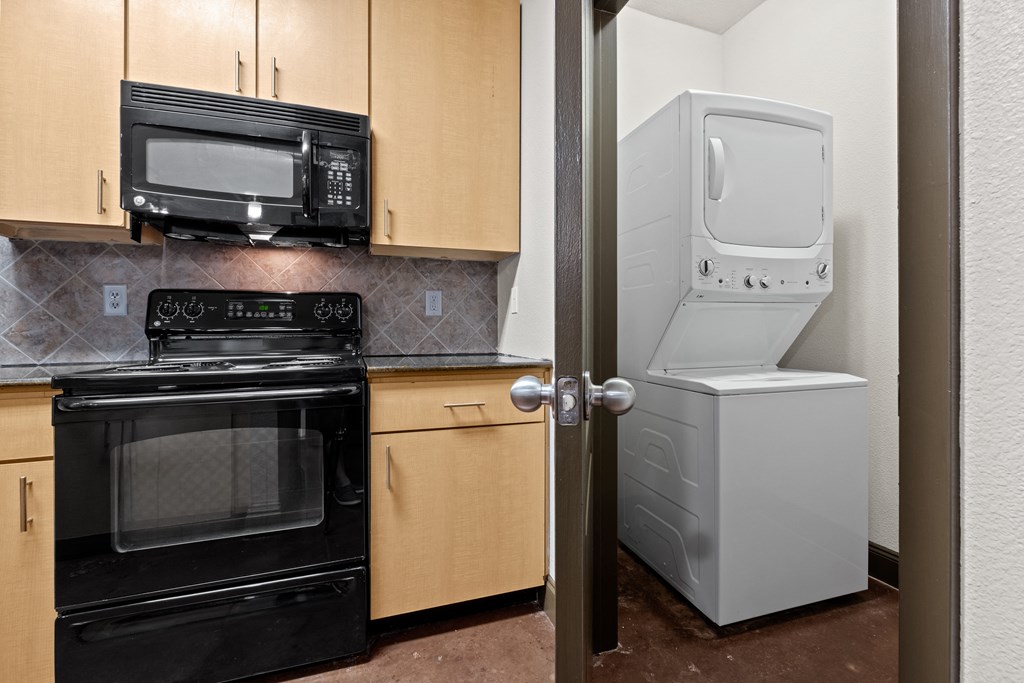 a kitchen with a refrigerator and a stove and a microwave at The Millennium Towne Center Apartments, Louisiana