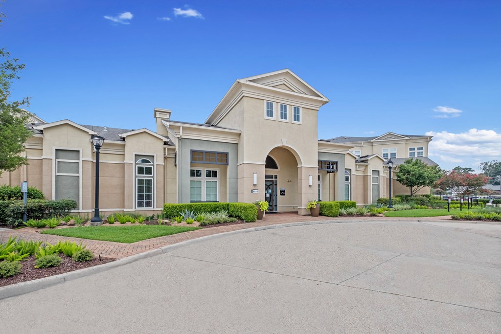 the front of a building with a driveway and walkway at The Millennium Towne Center Apartments, Baton Rouge