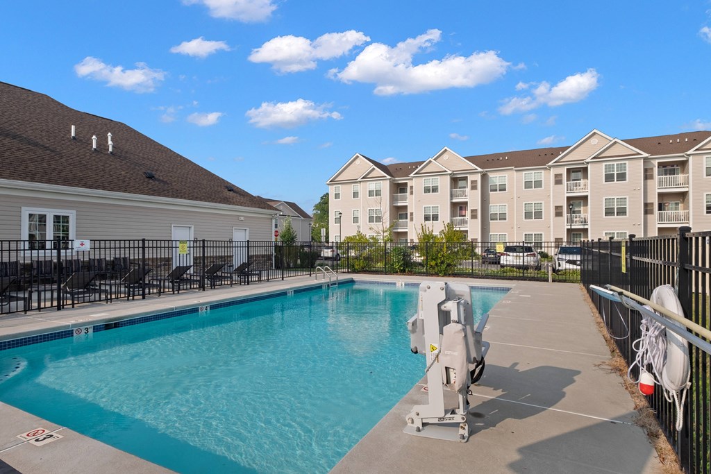 a swimming pool with apartment buildings in the background at The Landing Apartment , Hazlet, NJ