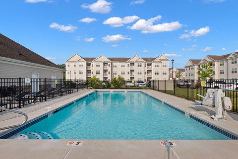 a swimming pool with apartment buildings in the background at The Landing Apartment, Hazlet, NJ, 07730