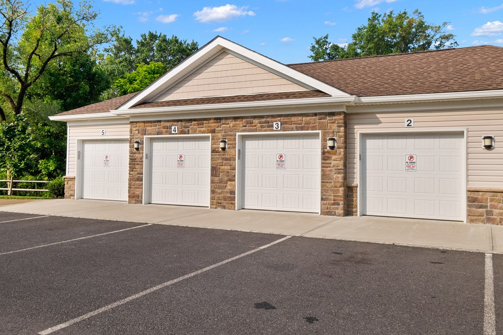 the front of a brick building with three garage doors at The Landing Apartment , Hazlet, 07730