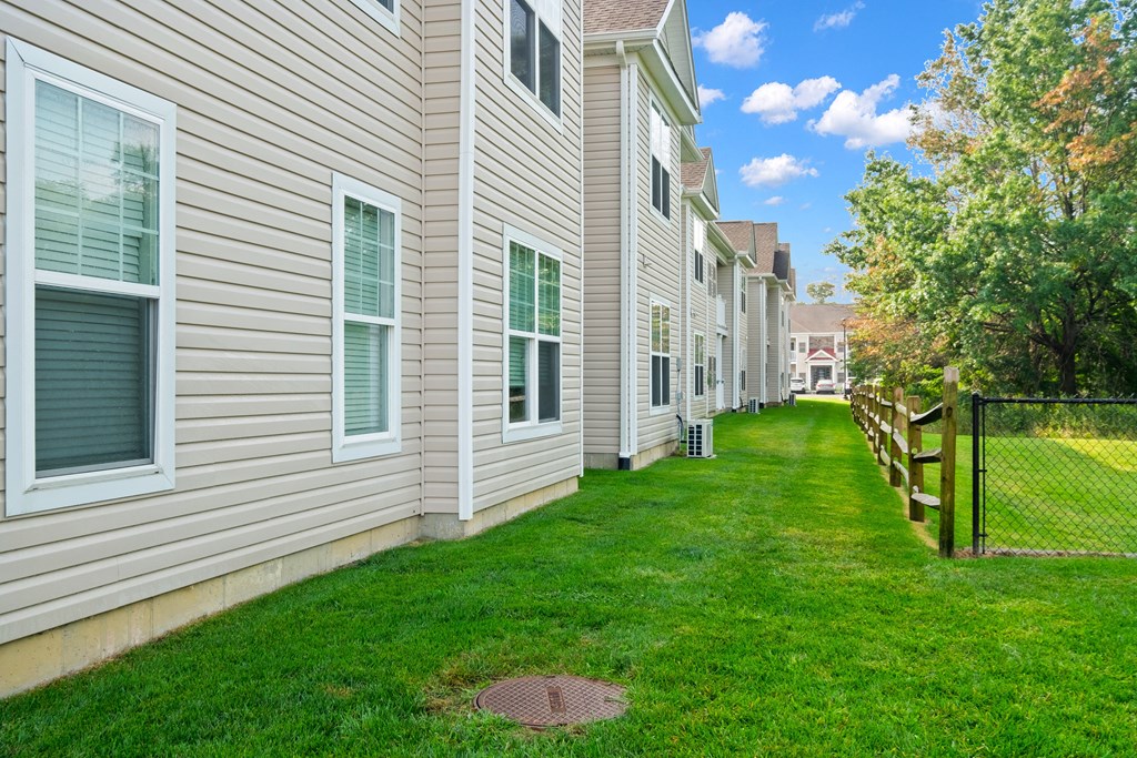 a green lawn in front of a white house at The Landing Apartment , Hazlet, NJ