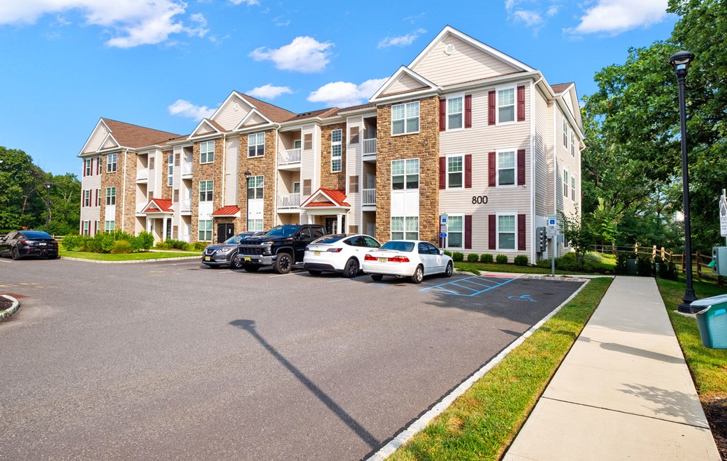 a large apartment building with cars parked in front of it at The Landing Apartment , New Jersey