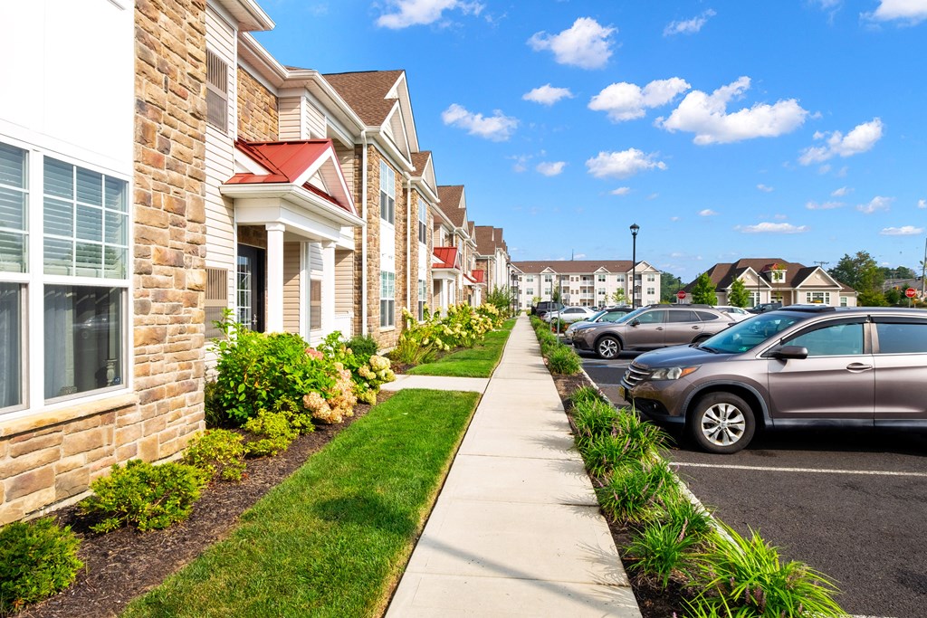 a row of houses with cars parked in front of them at The Landing Apartment , Hazlet