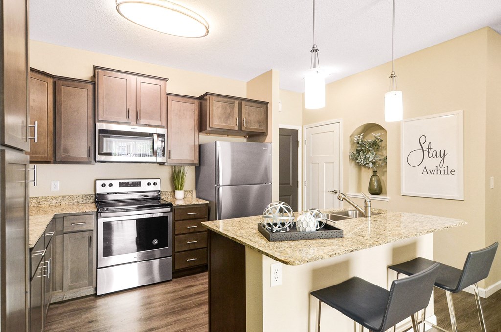 a kitchen with stainless steel appliances and a granite countertop at Skye at Arbor Lakes, Maple Grove, Minnesota