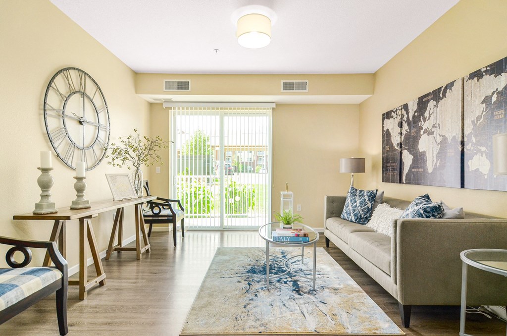 a living room with beige walls and a large clock on the wall at Skye at Arbor Lakes, Maple Grove, 55369