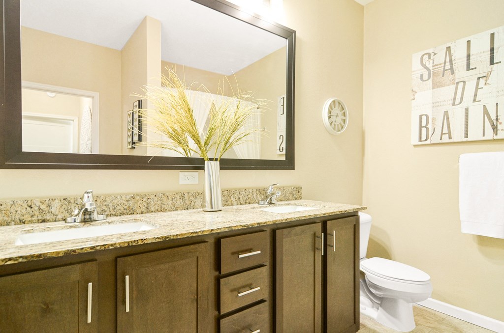 a bathroom with two sinks and a toilet at Skye at Arbor Lakes, Maple Grove, Minnesota