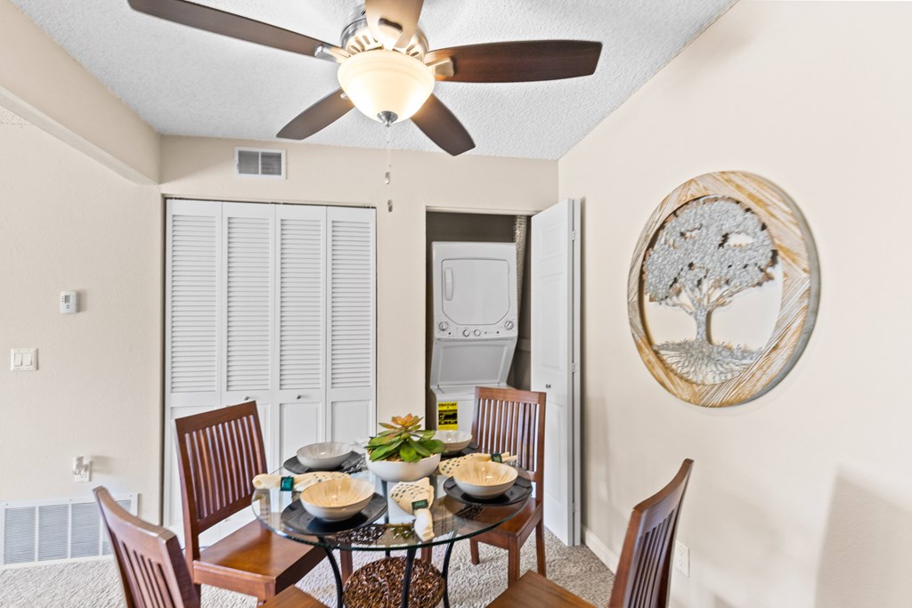 a dining room with a table and chairs and a ceiling fan