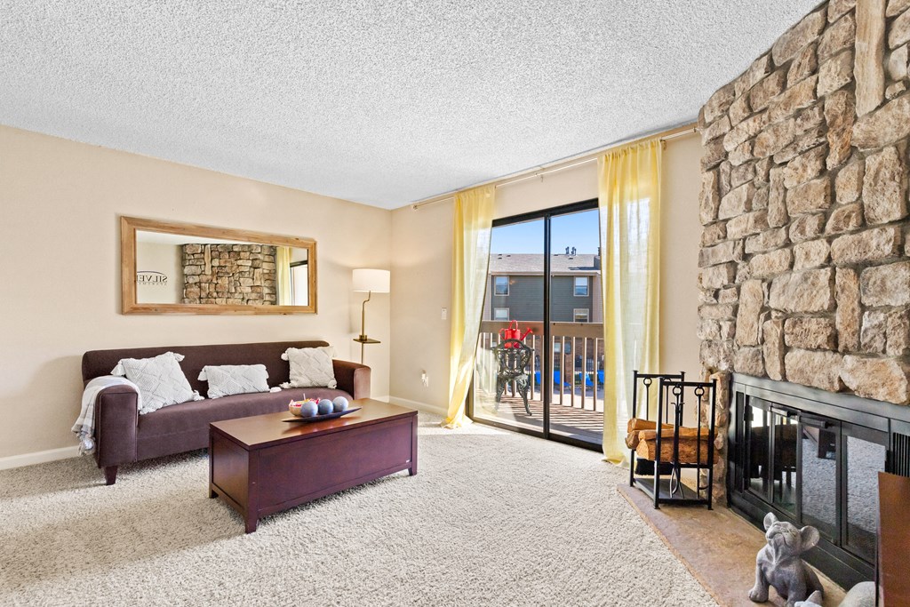 a living room with a stone fireplace and a couch