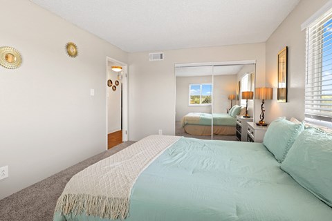 a bedroom with a large bed and a large mirror at Park 88 Apartments, Thornton, Colorado