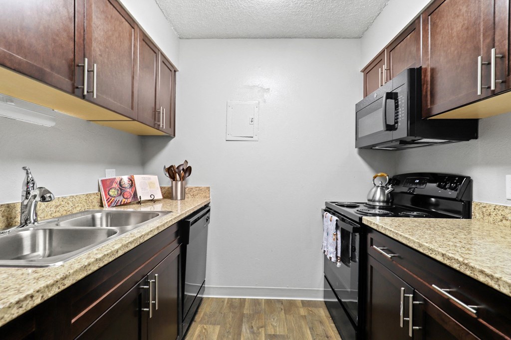 a kitchen with dark wood cabinets and granite countertops