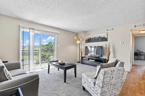a living room with a couch coffee table and a tv at Park 88 Apartments, Thornton, Colorado