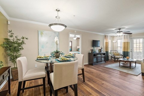 a living room and dining room with a table and chairs