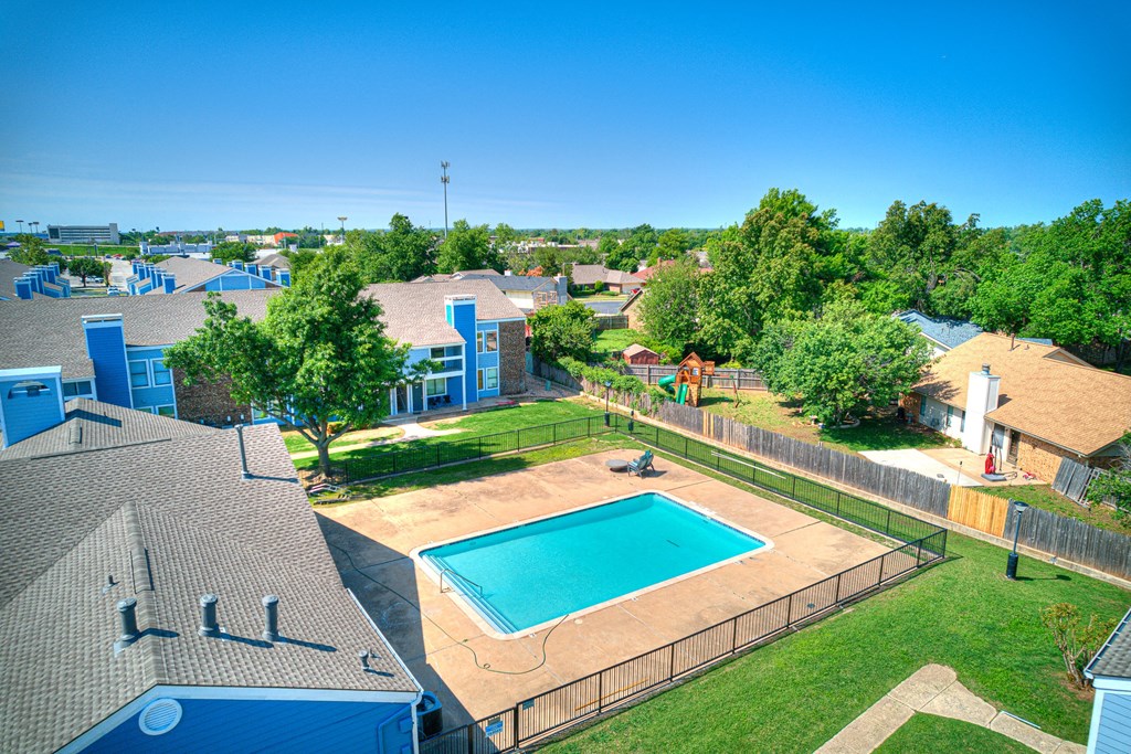 an aerial view of a swimming pool in the backyard of a house