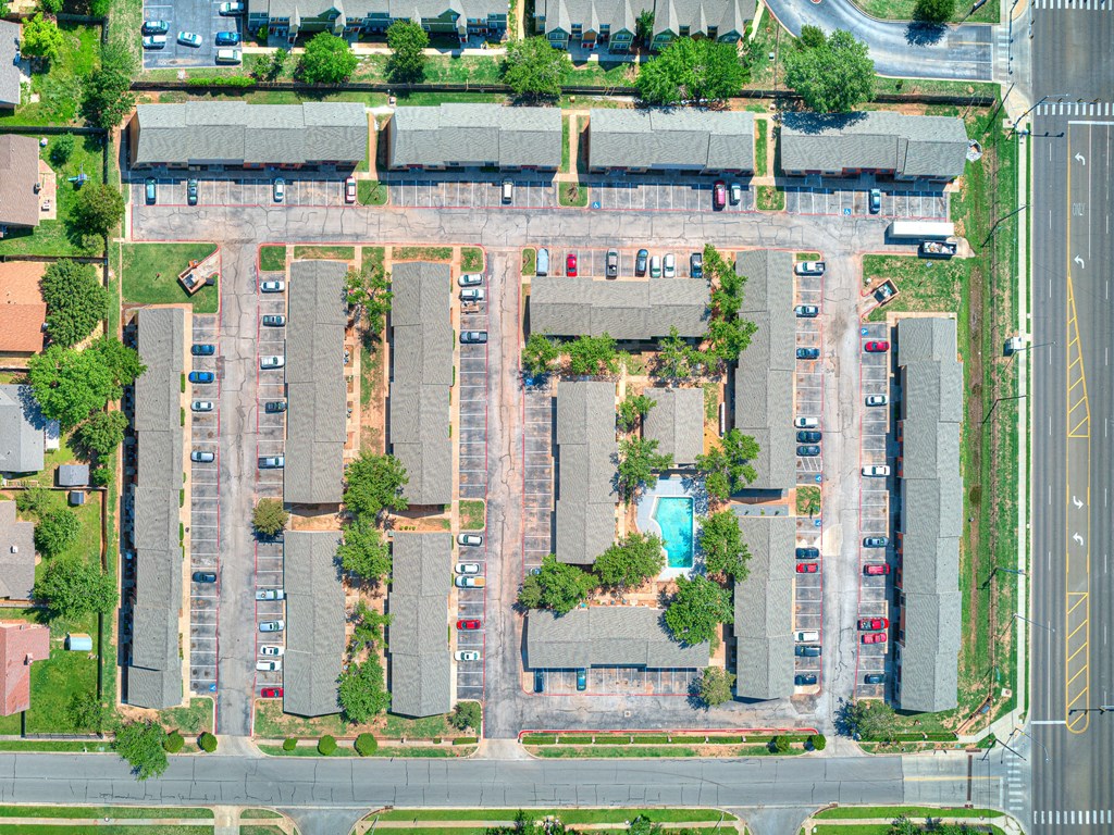an aerial view of a parking lot with cars and trees