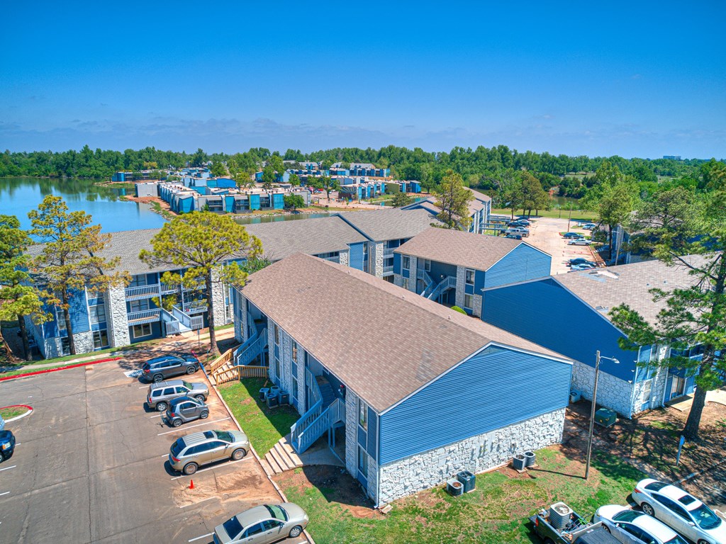 an aerial view of a building with a lake in the background