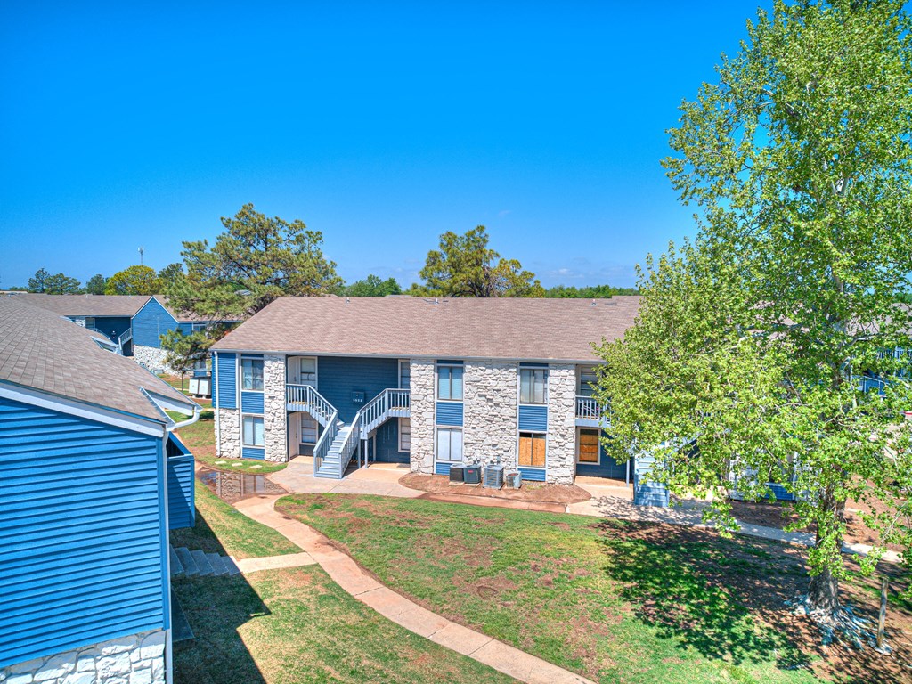 a blue house with a yard and trees in front of it