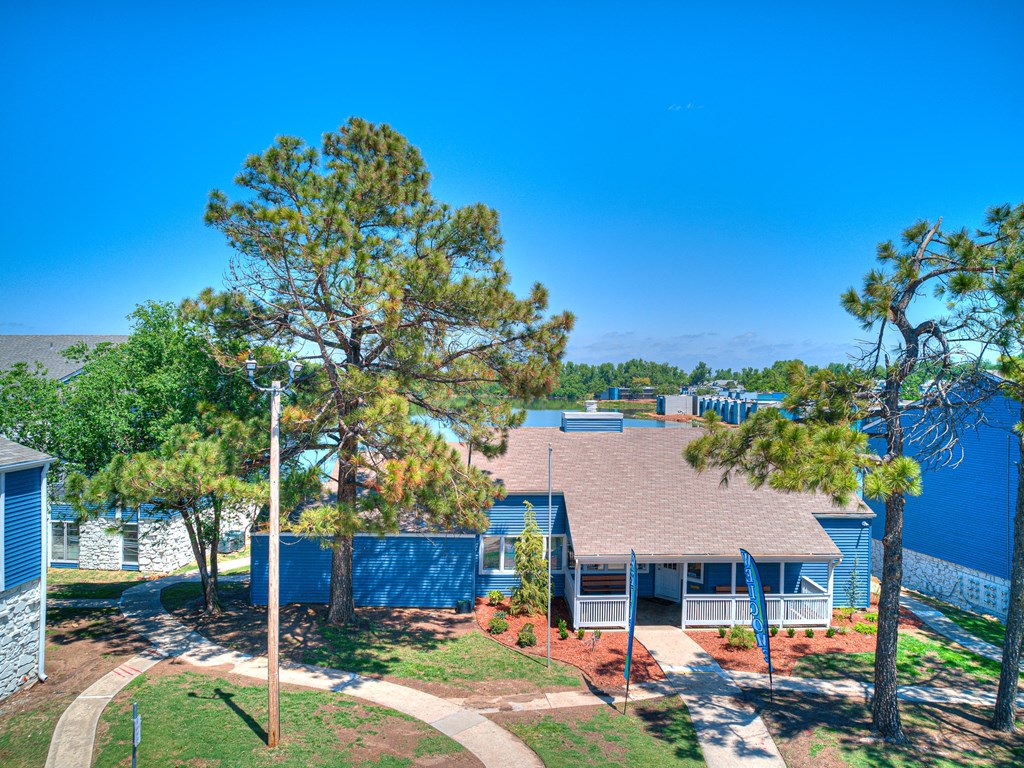 an aerial view of a house with trees and a blue fence