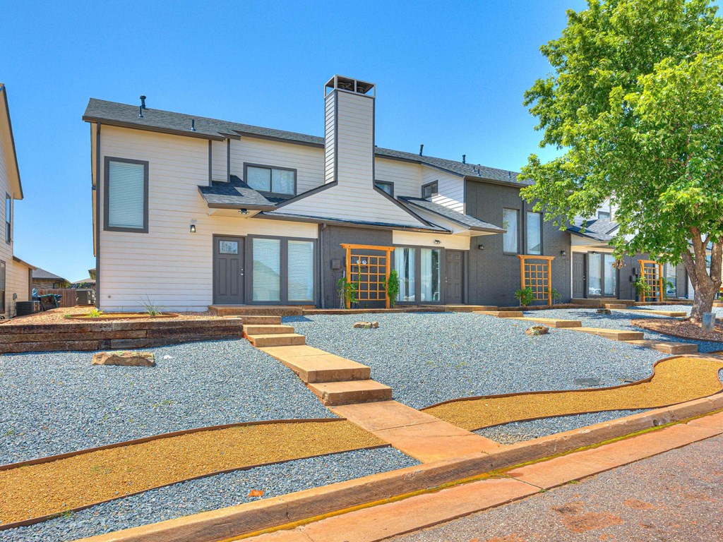 the front of a house with a gravel yard and a tree at Diamond Ridge Townhomes, Oklahoma City, OK 73114