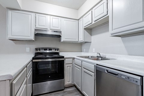 A kitchen with white cabinets and stainless steel appliances.