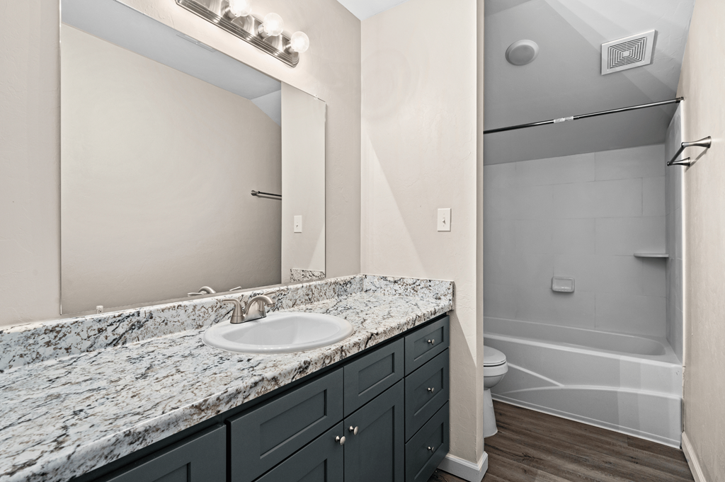 a bathroom with a sink and a shower and a mirror at Diamond Ridge Townhomes, Oklahoma City Oklahoma