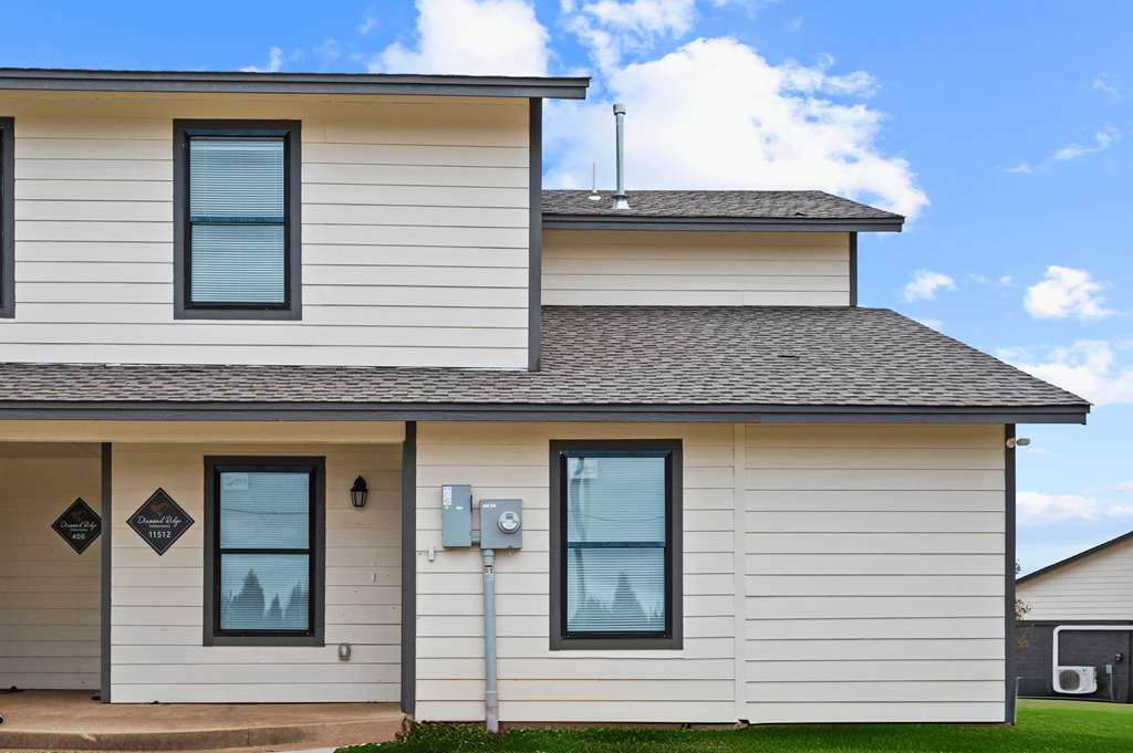 the front of a white house with a gray roof at Diamond Ridge Townhomes, Oklahoma