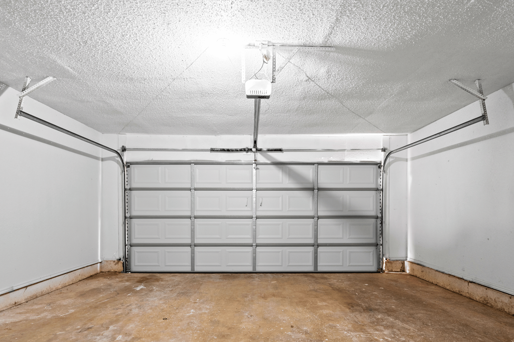 the inside of a garage with white walls and a concrete floor at Diamond Ridge Townhomes, Oklahoma