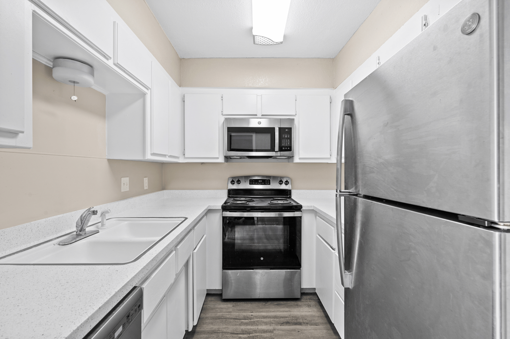 a white kitchen with stainless steel appliances and white cabinets at Diamond Ridge Townhomes, Oklahoma ,73114