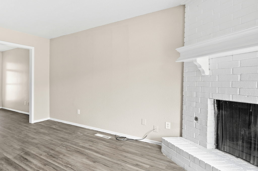 an empty living room with white walls and a fireplace at Diamond Ridge Townhomes, Oklahoma City, OK 73114
