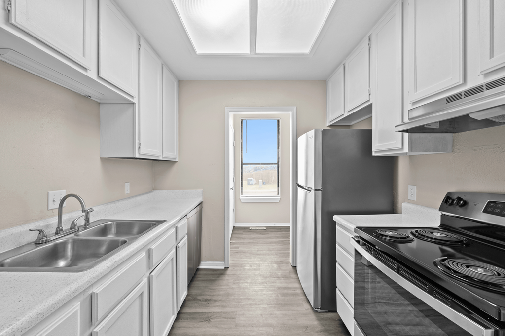 a kitchen with white cabinets and stainless steel appliances and a window at Diamond Ridge Townhomes, Oklahoma City Oklahoma