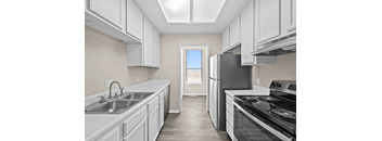 A kitchen with white cabinets and a black stove top oven.