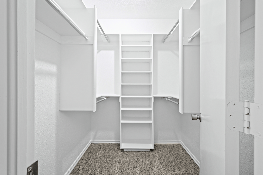 a walk in closet with white shelves and a spiral staircase at Diamond Ridge Townhomes, Oklahoma City, 73114