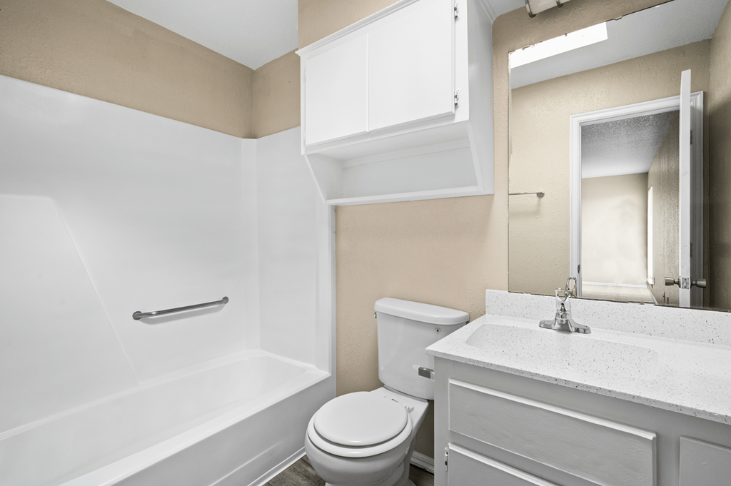 a bathroom with a toilet and a sink and a bath tub at Diamond Ridge Townhomes, Oklahoma City