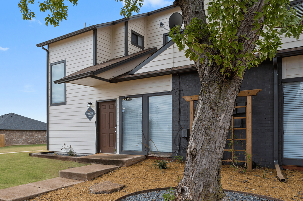 a white and black house with a tree in front of it at Diamond Ridge Townhomes, Oklahoma City, OK