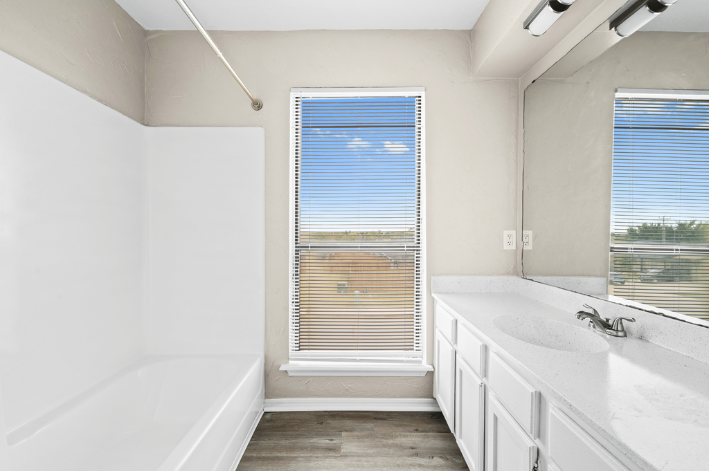 a bathroom with a tub and a sink and a window at Diamond Ridge Townhomes, Oklahoma ,73114
