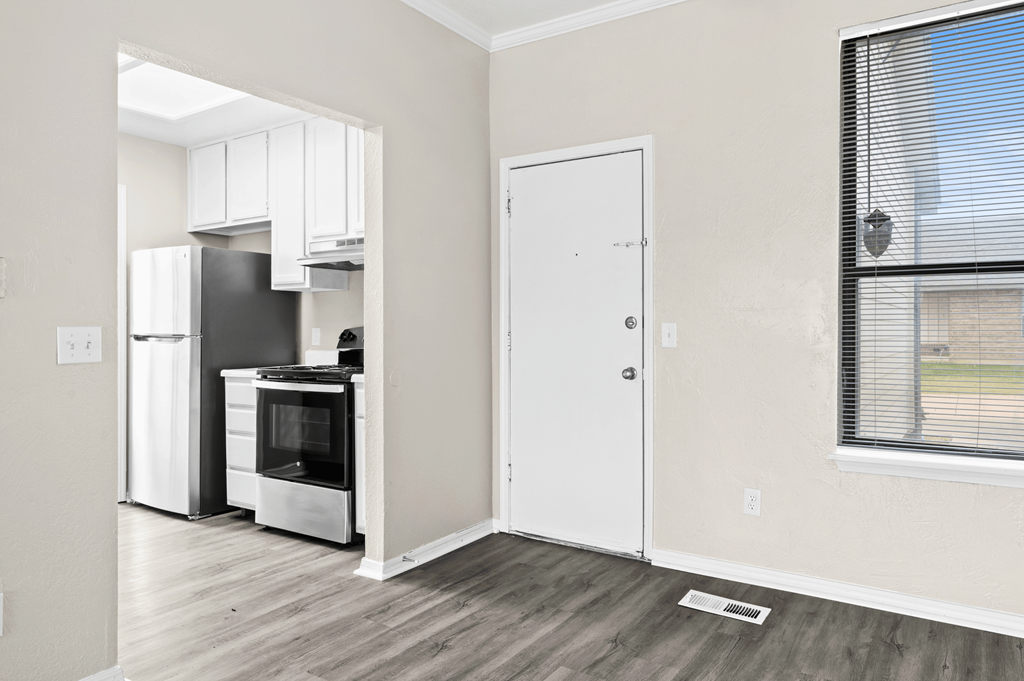 an empty room with a kitchen and a window and a refrigerator at Diamond Ridge Townhomes, Oklahoma ,73114