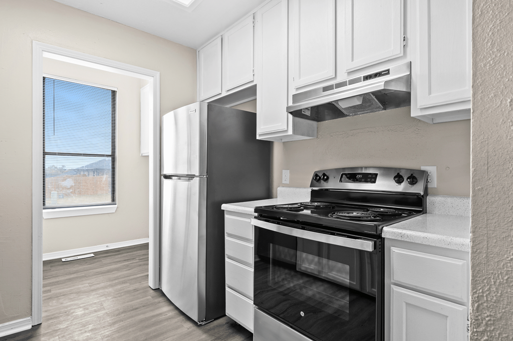 an empty kitchen with a stove and a refrigerator at Diamond Ridge Townhomes, Oklahoma City, OK 73114
